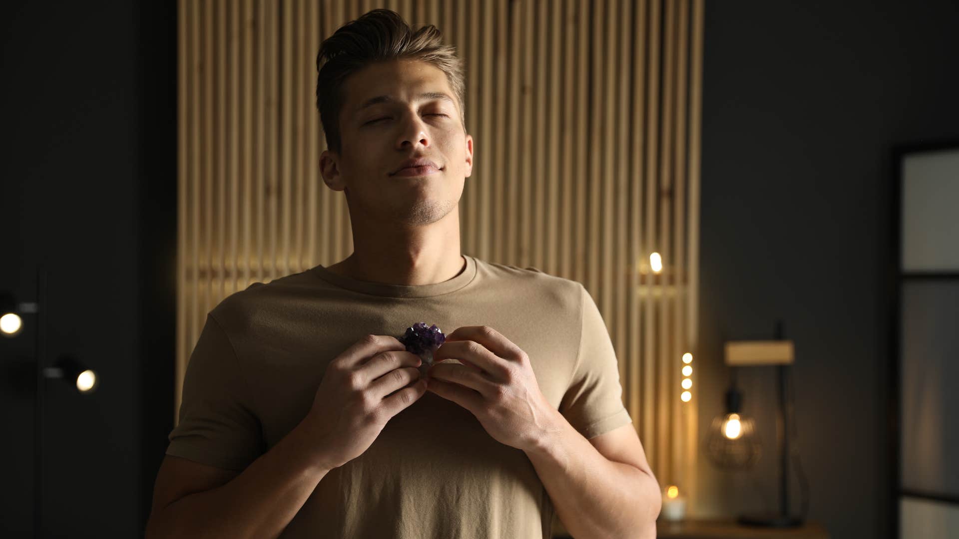 happy man with a spiritual routine holding crystals