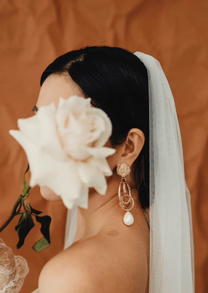 large white rose covering bride's face