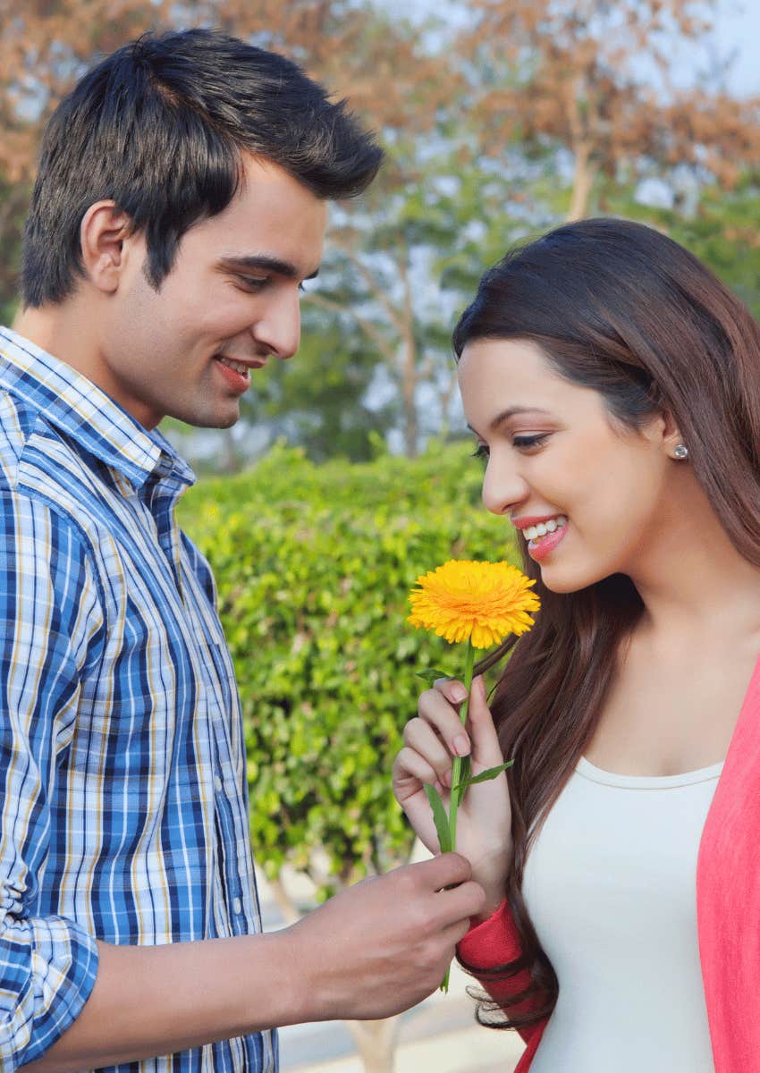 woman accepting flower from persistent man