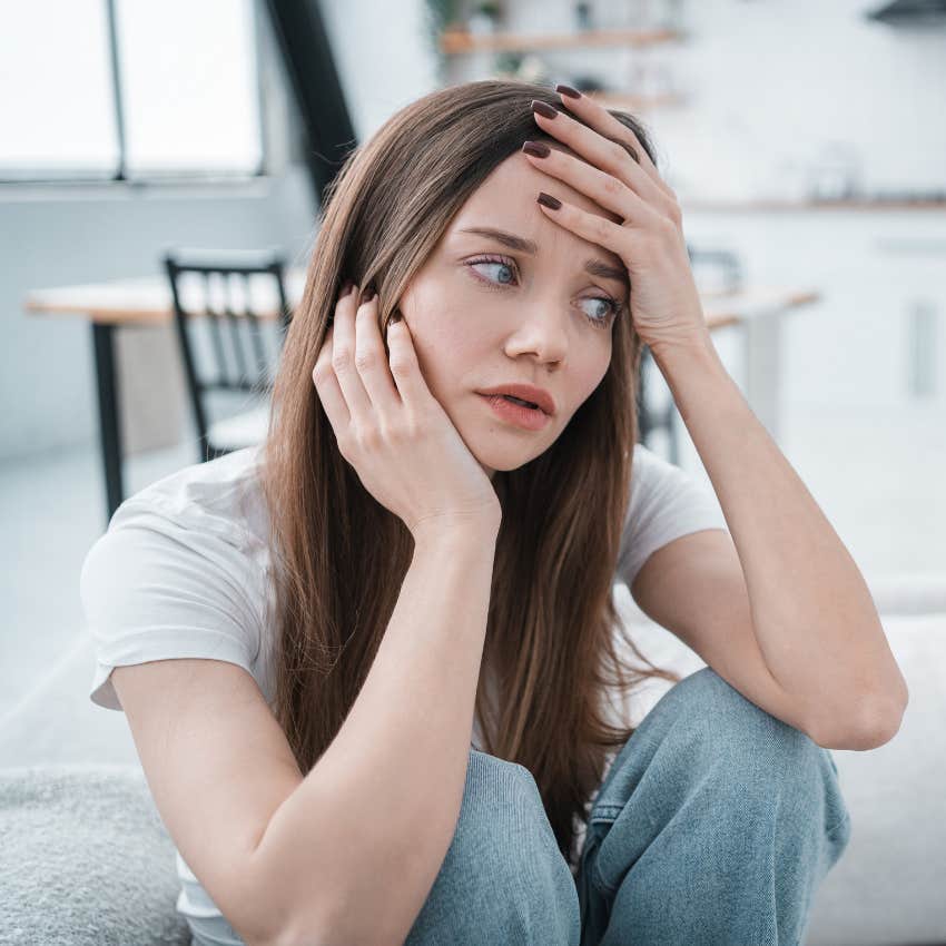 worried woman sitting on floor at home