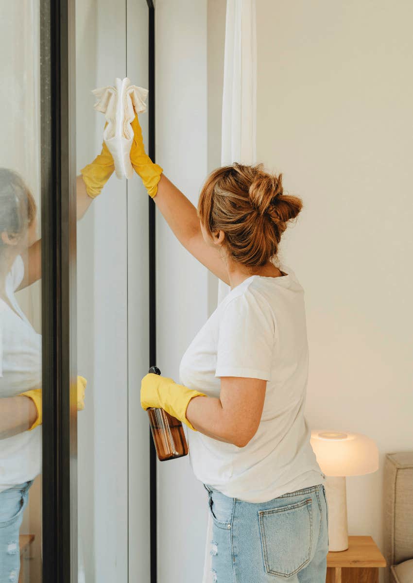 woman cleaning large windows