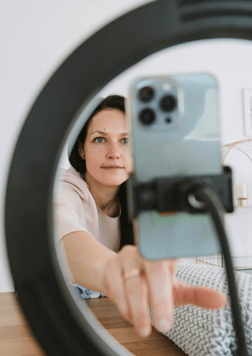 woman setting up phone on ring light mount