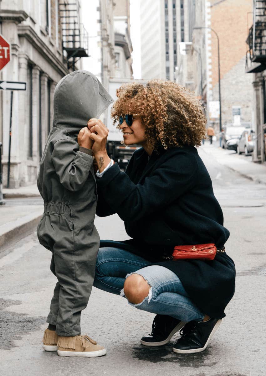 woman squatting down to speak to child