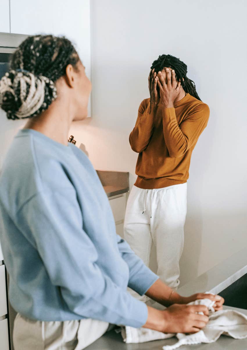 woman watching frustrated man covering face
