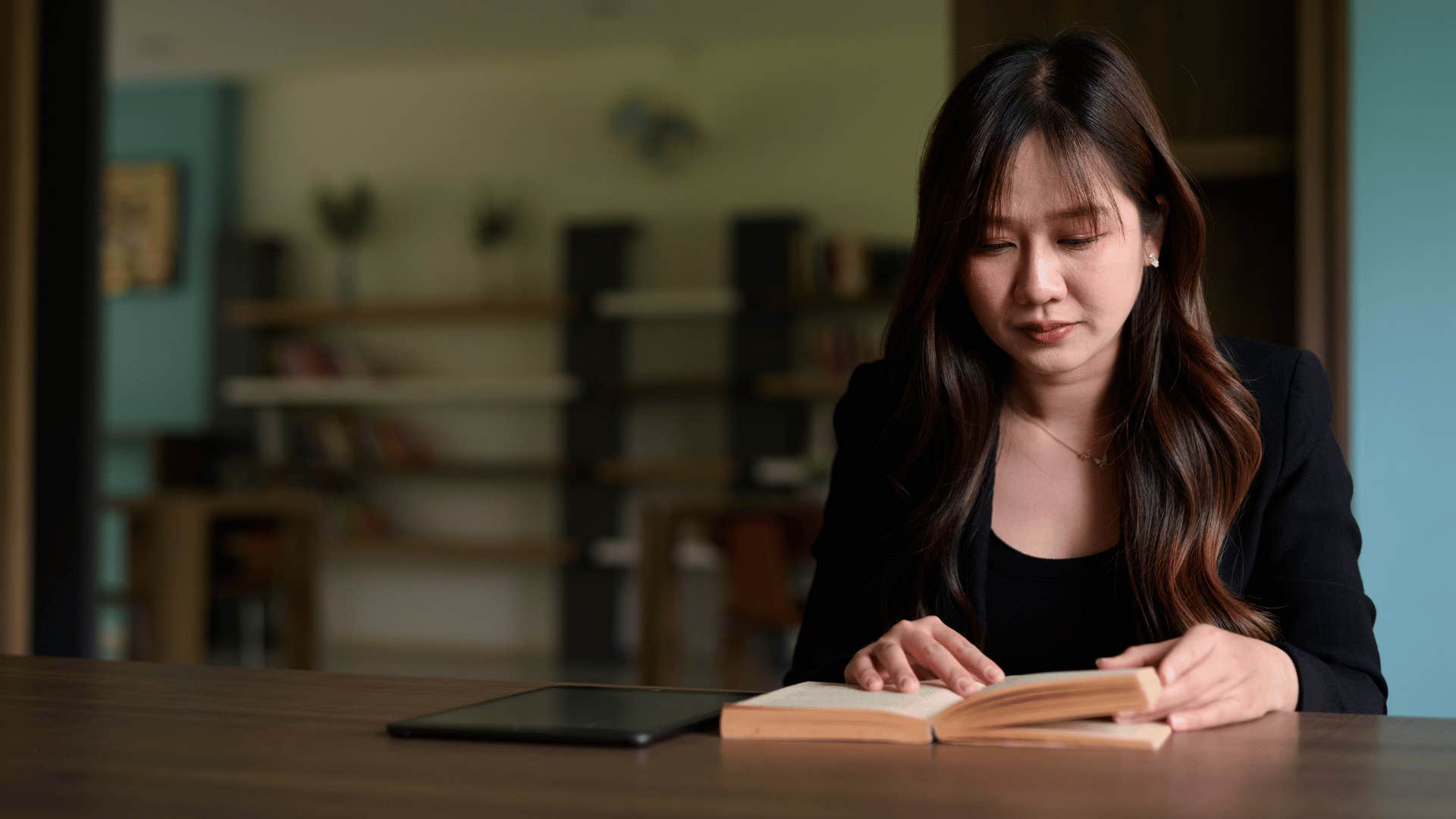 woman often called a know it all reading a book in a library