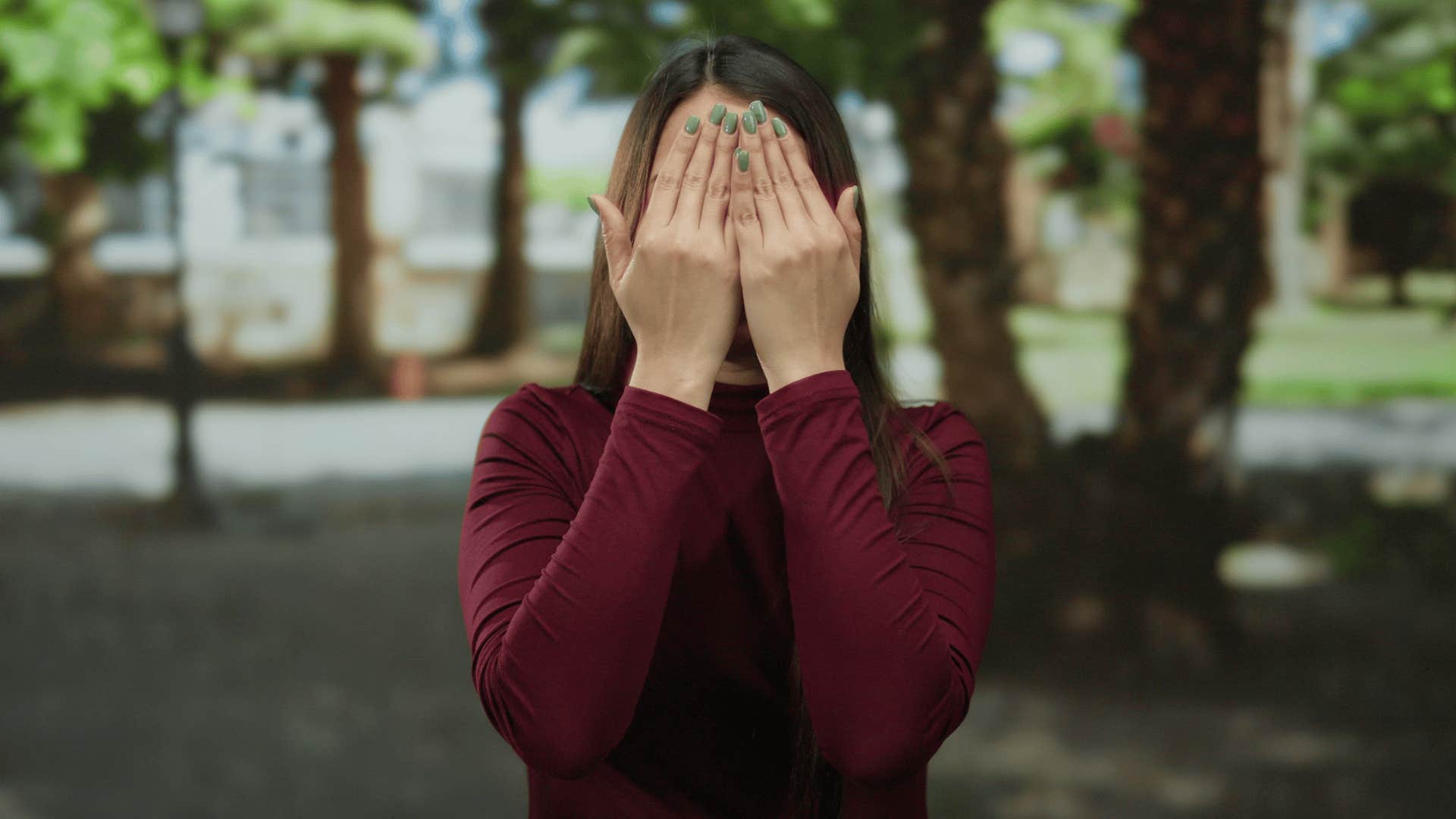 shy quiet woman covering her face outside
