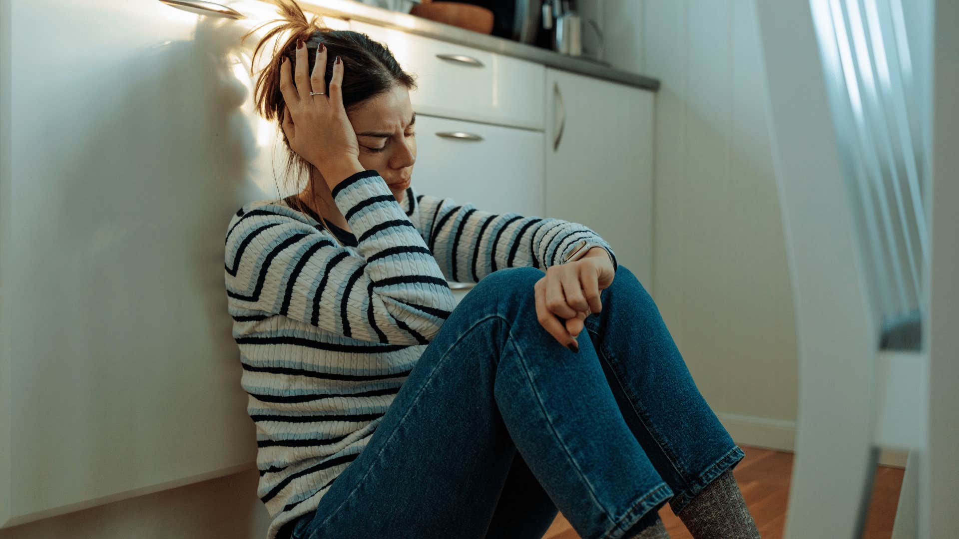 sensitive woman feeling sad sitting on the floor at home