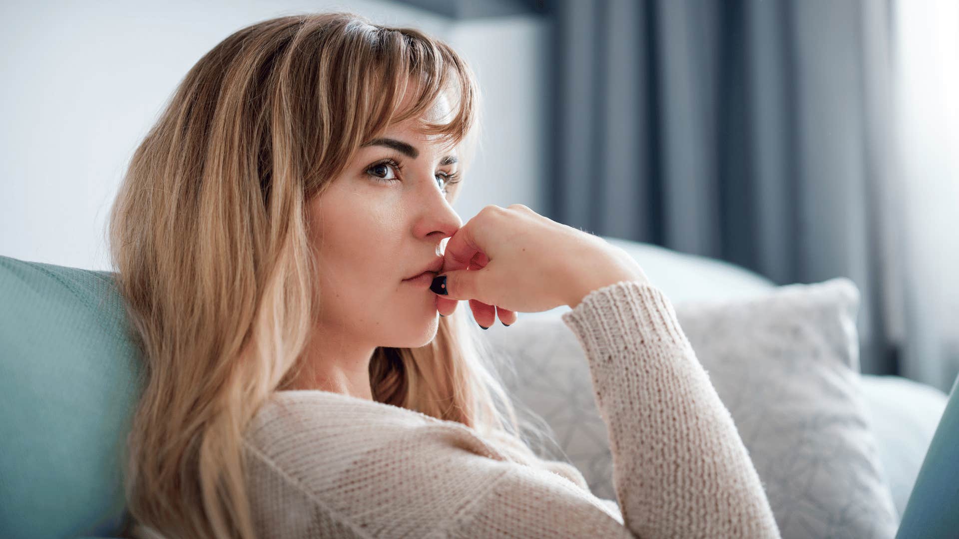 pensive woman sitting at home feeling unpredictable