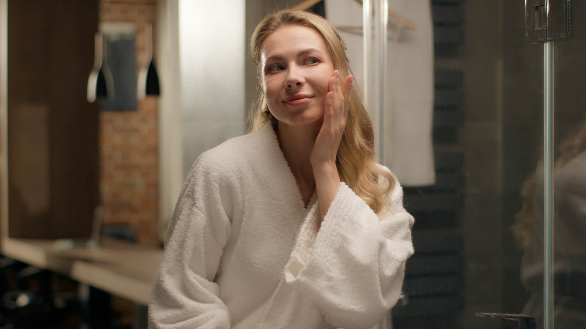happy woman who loves early bedtimes looking at herself in the mirror