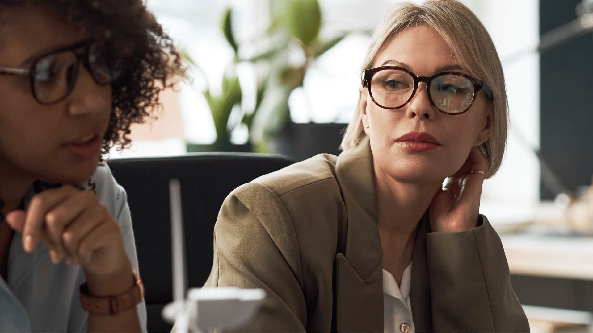 Woman saying she works best under pressure to a colleague
