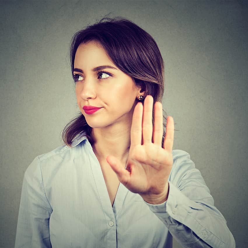 woman holding up hand annoyed