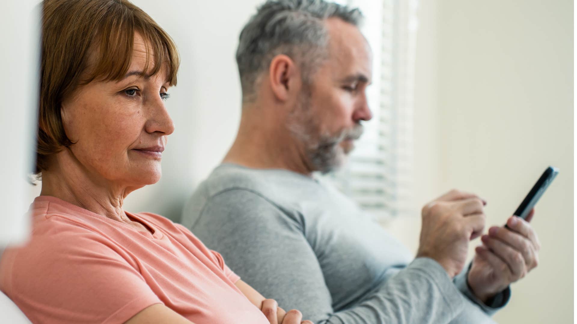 immature husband pushing limits with his wife by ignoring her on his phone