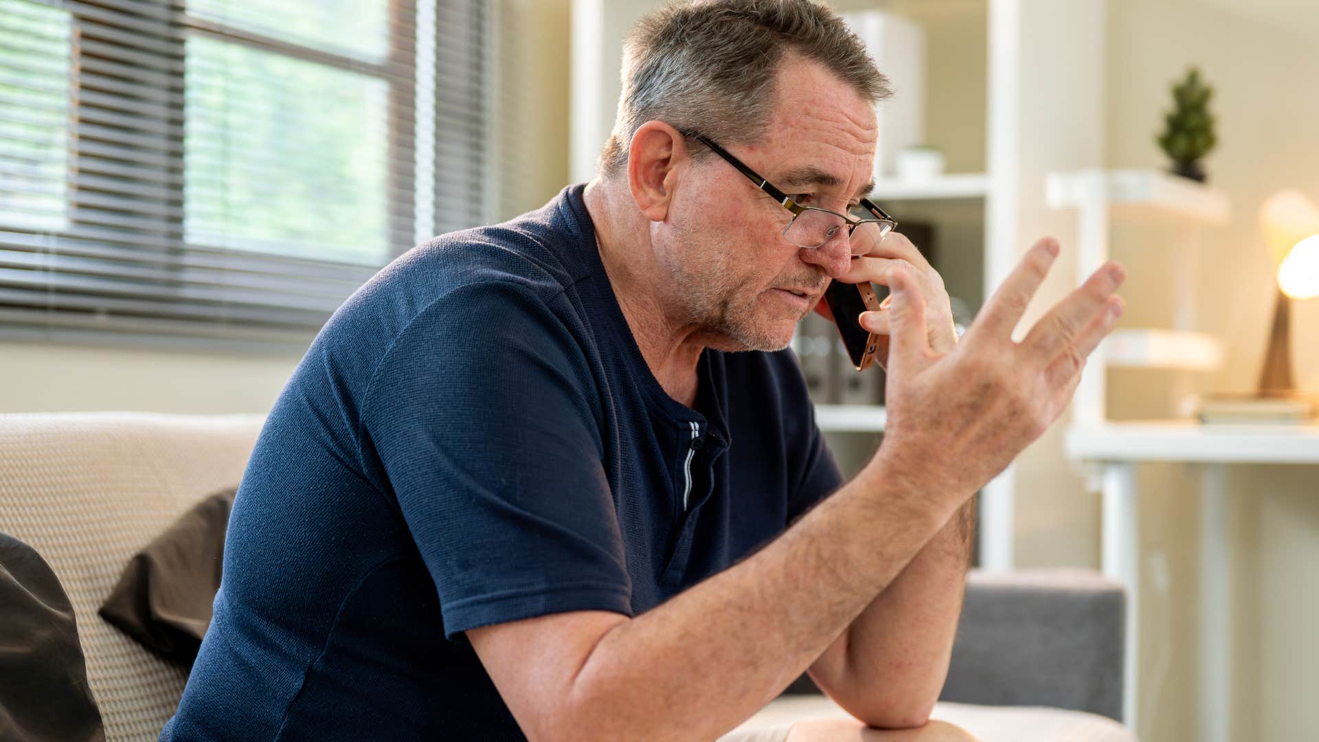 sad man saying I can't on the phone to his friend
