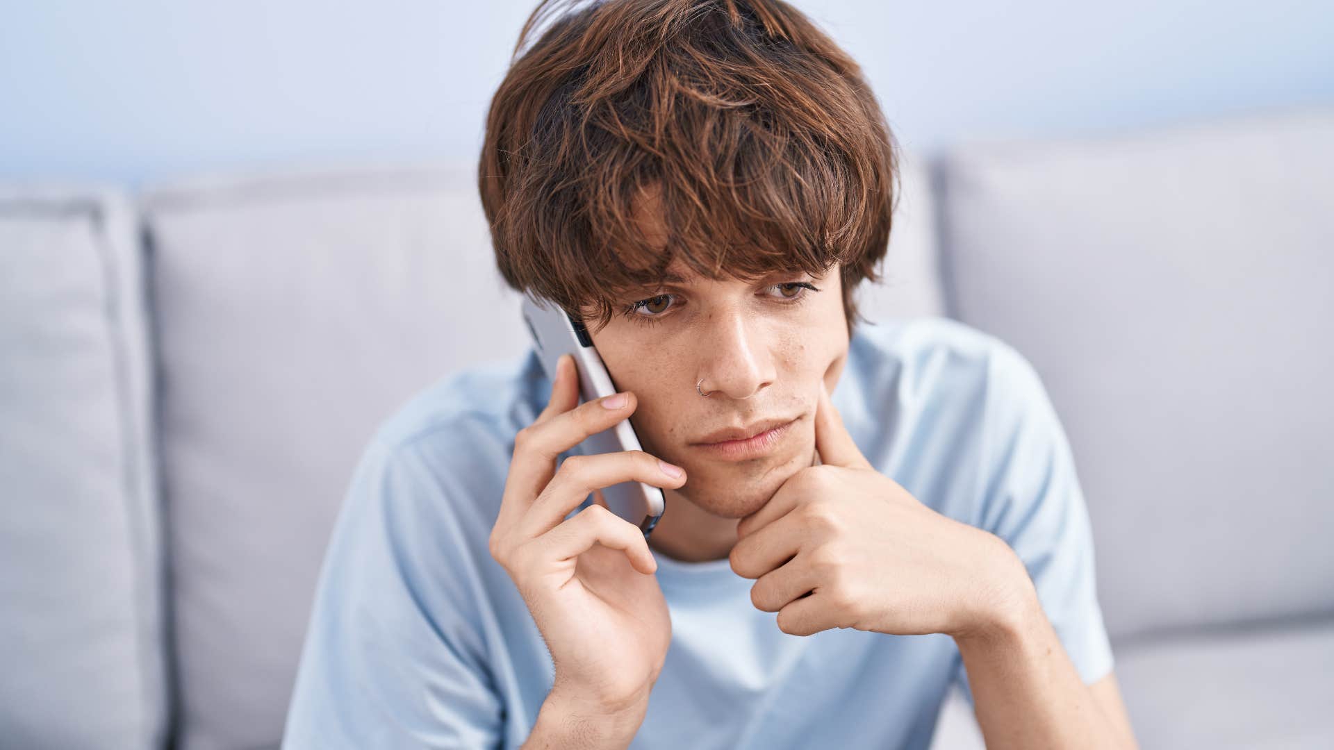 young man feeling sad saying i don't care on the phone