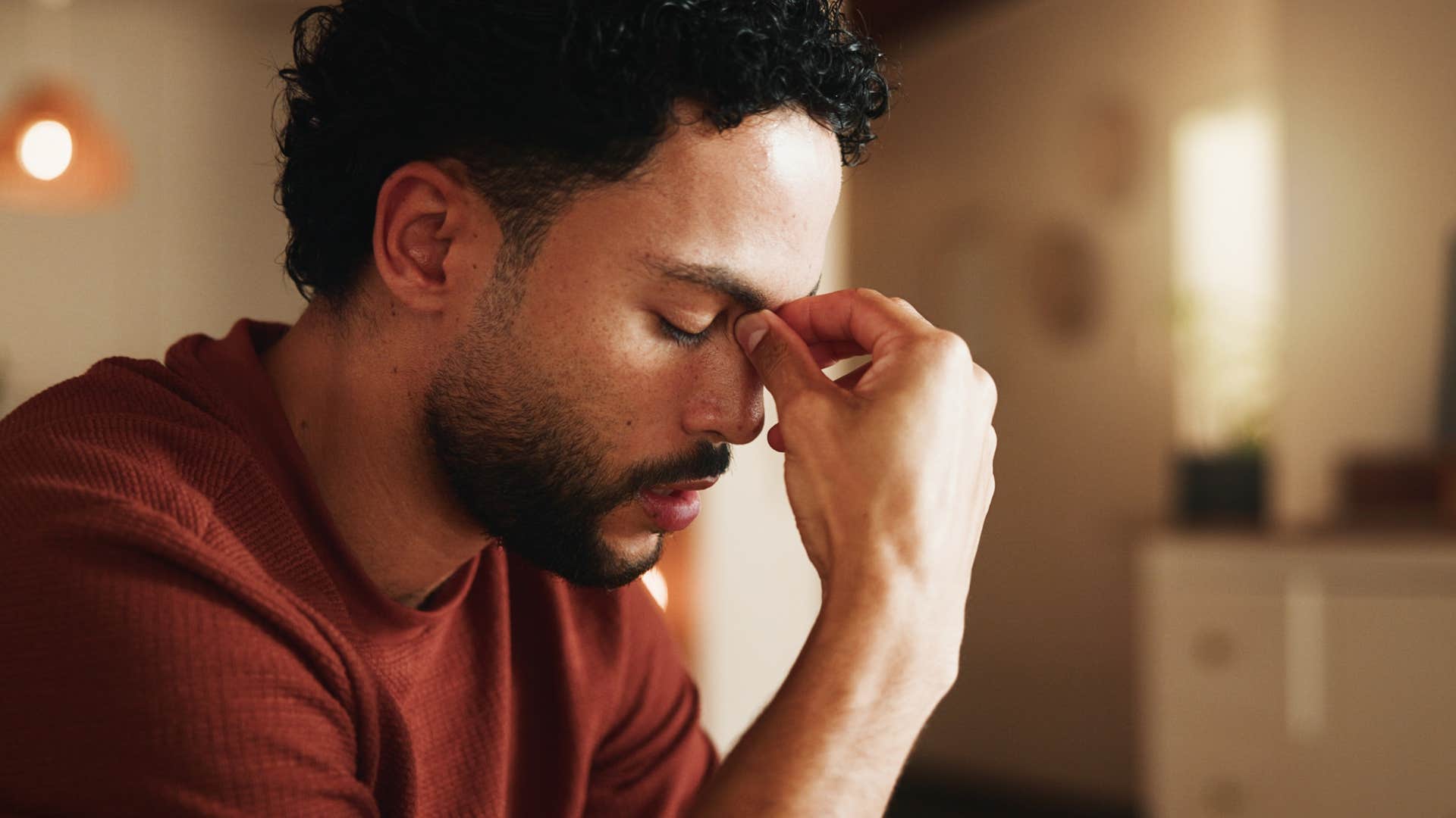 sad man saying I'm just tired holding his head in his hands