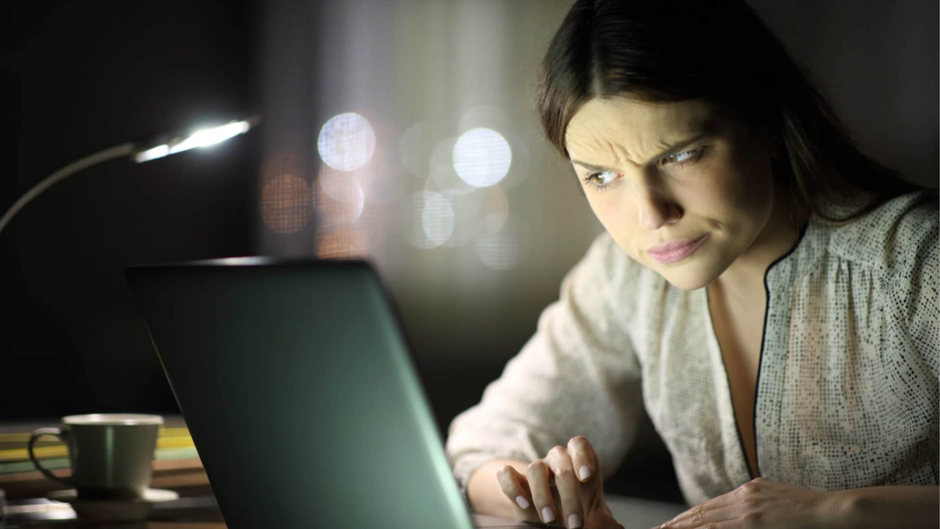 Woman who was yelled at as a child looking dubiously at the laptop