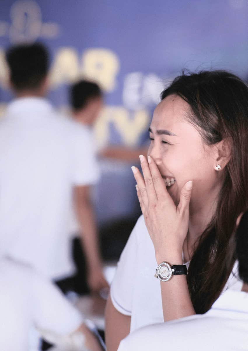 young woman trying to hide her laugh