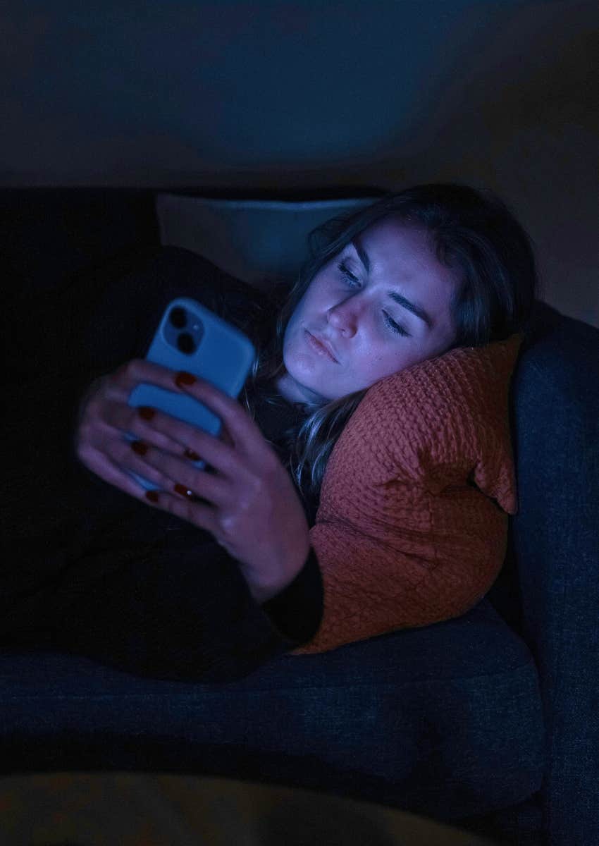 young woman scrolling on her phone wide awake