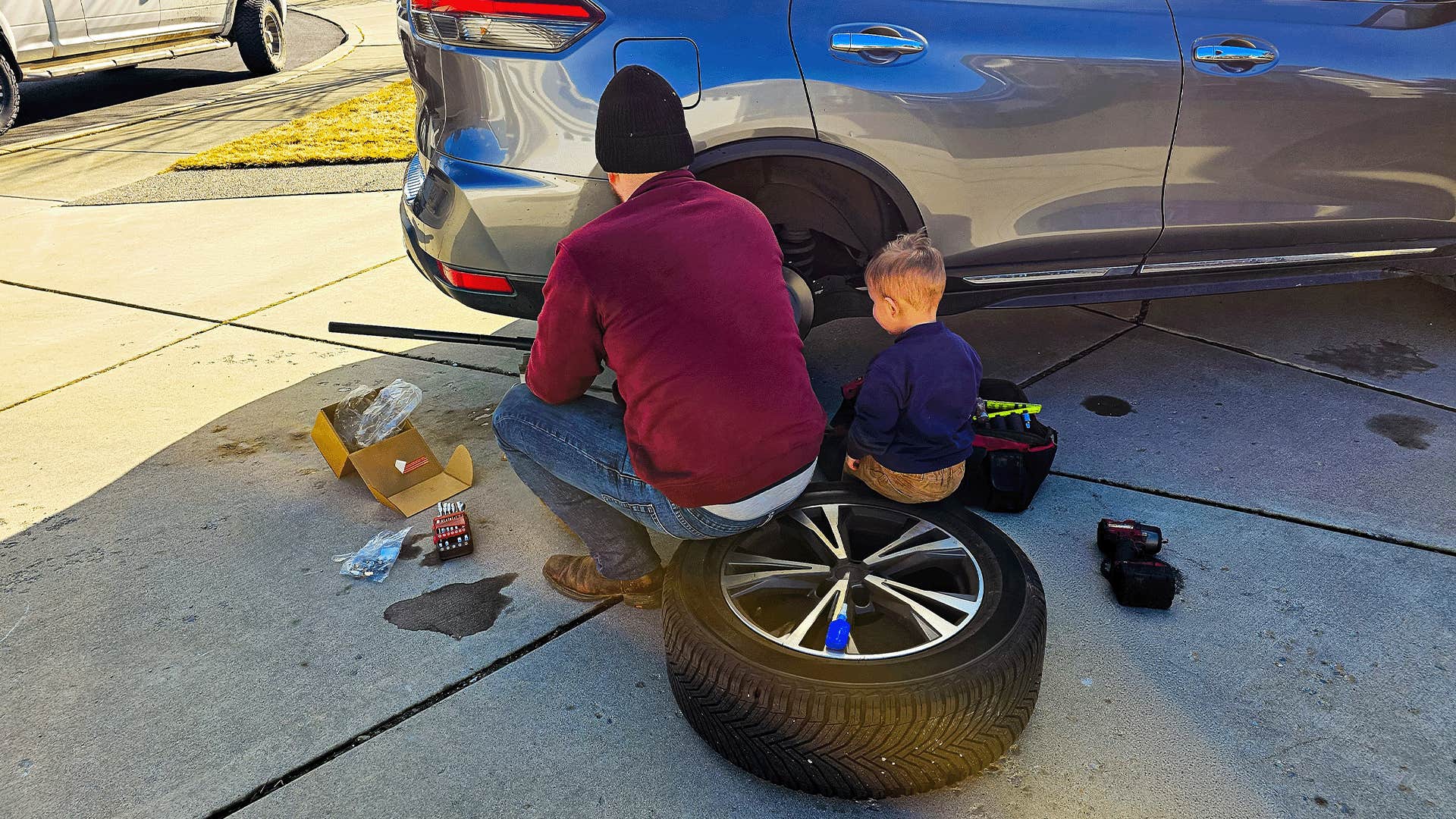 dad teaching child how to change a tire