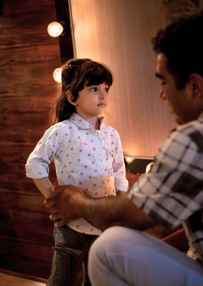 adult man talking to young girl