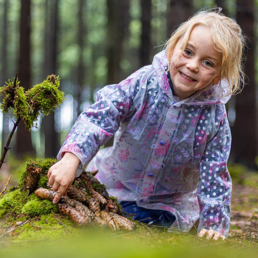 little girl collecting natural objects and trinkets in the dirt