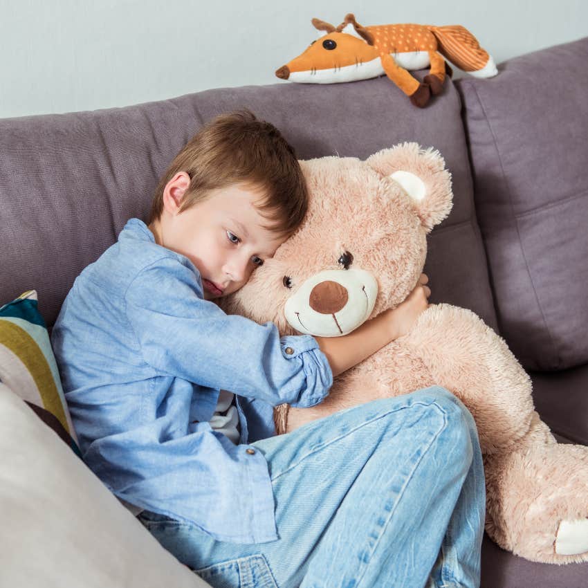 young boy talking to stuffed animals on the couch