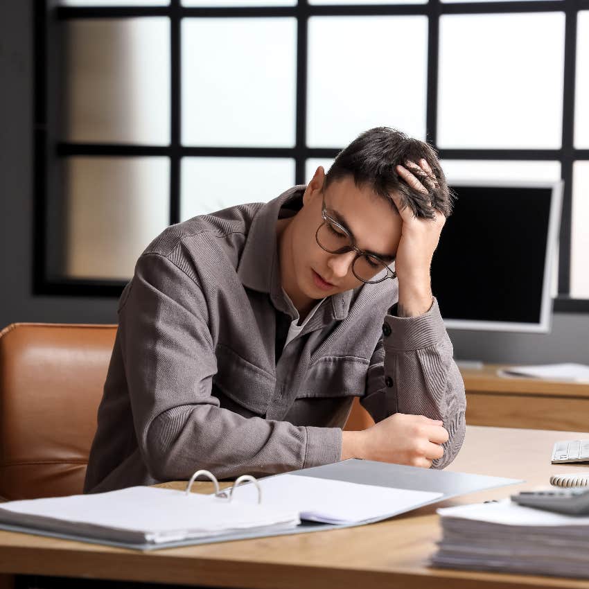 man stressed sitting at work desk american dream no longer exists