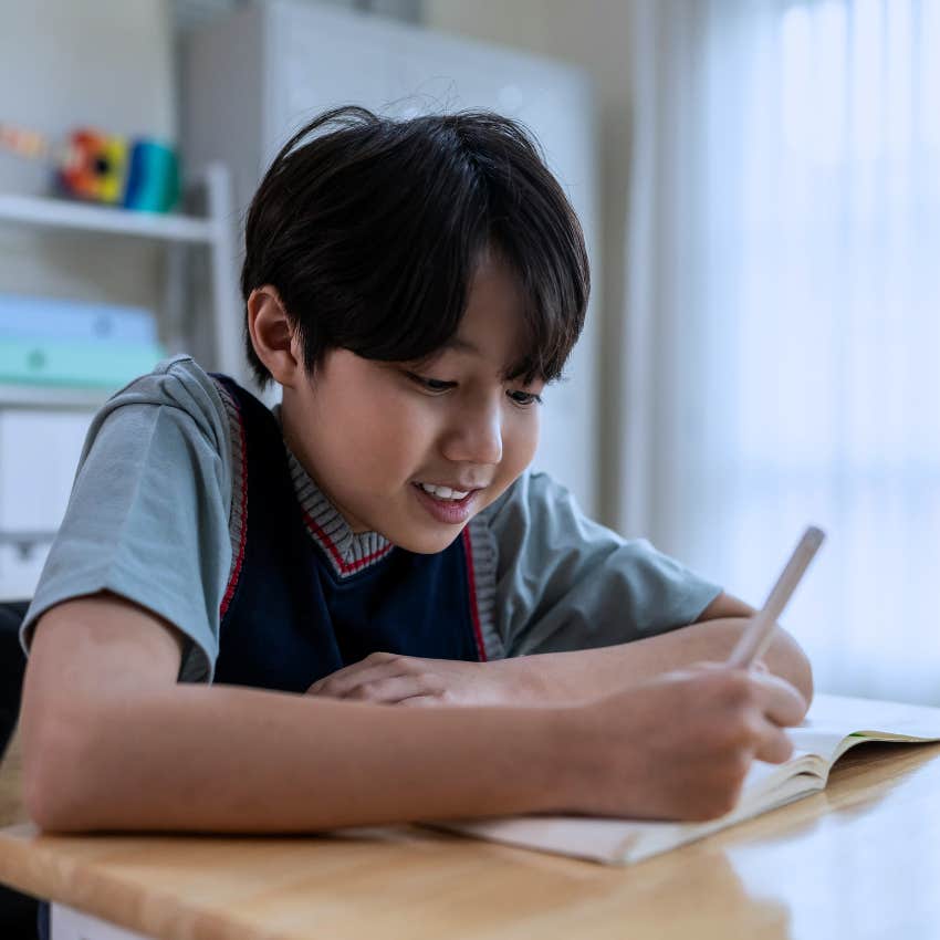 child learning penmanship and cursive while writing in school