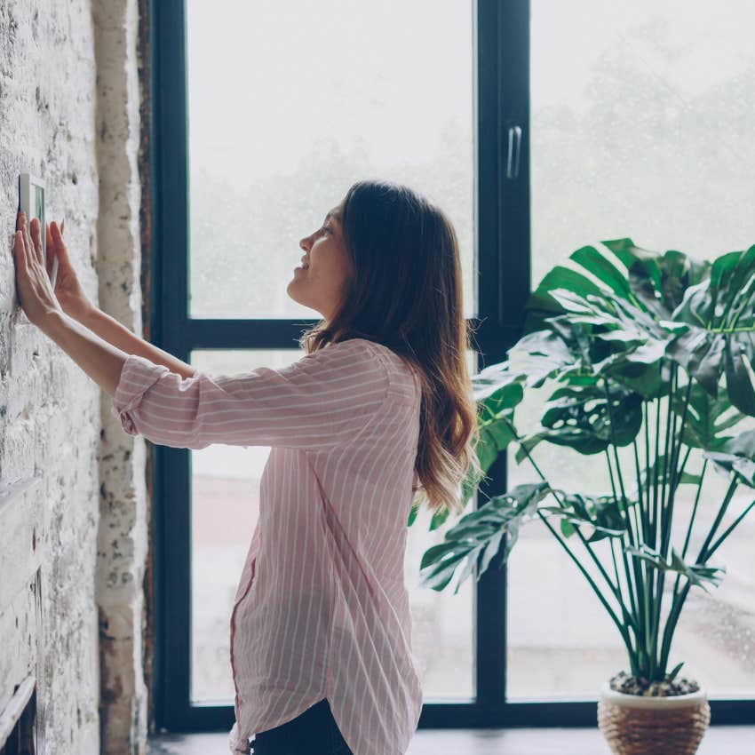 woman adjusting thermostat