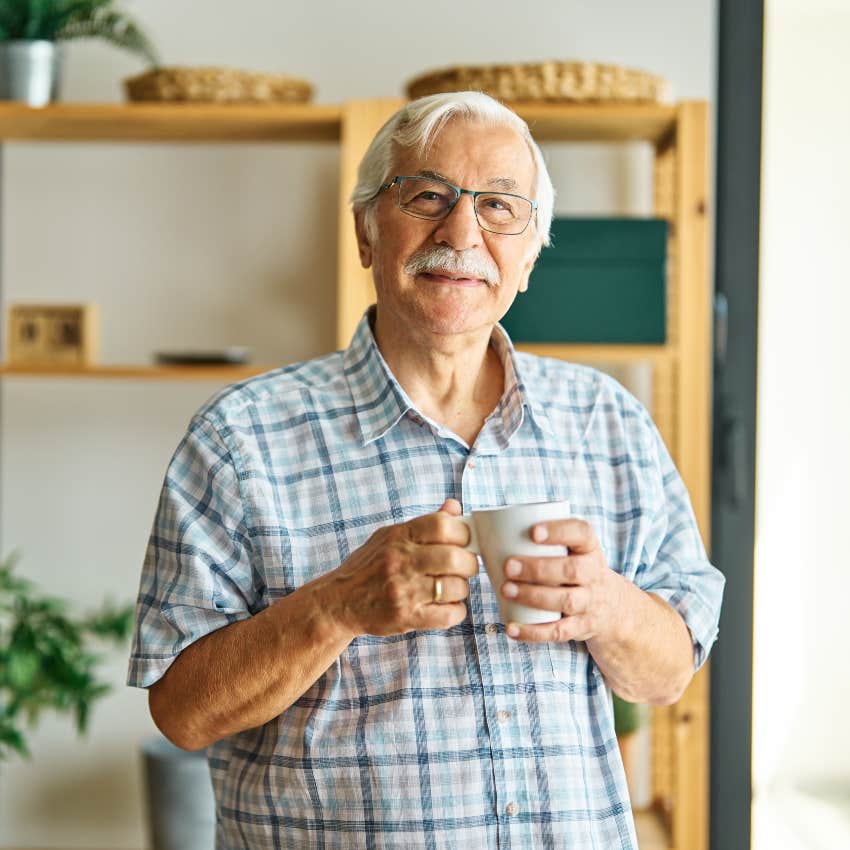 boomer man drinking coffee smiling at home