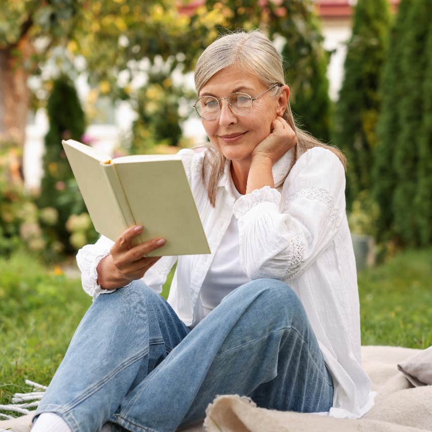 senior woman reading book outside