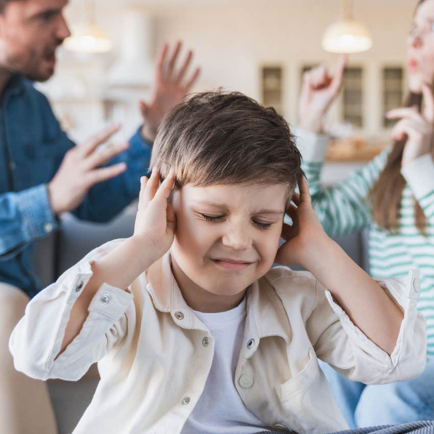 little boy being exposed to conflict with arguing parents at home