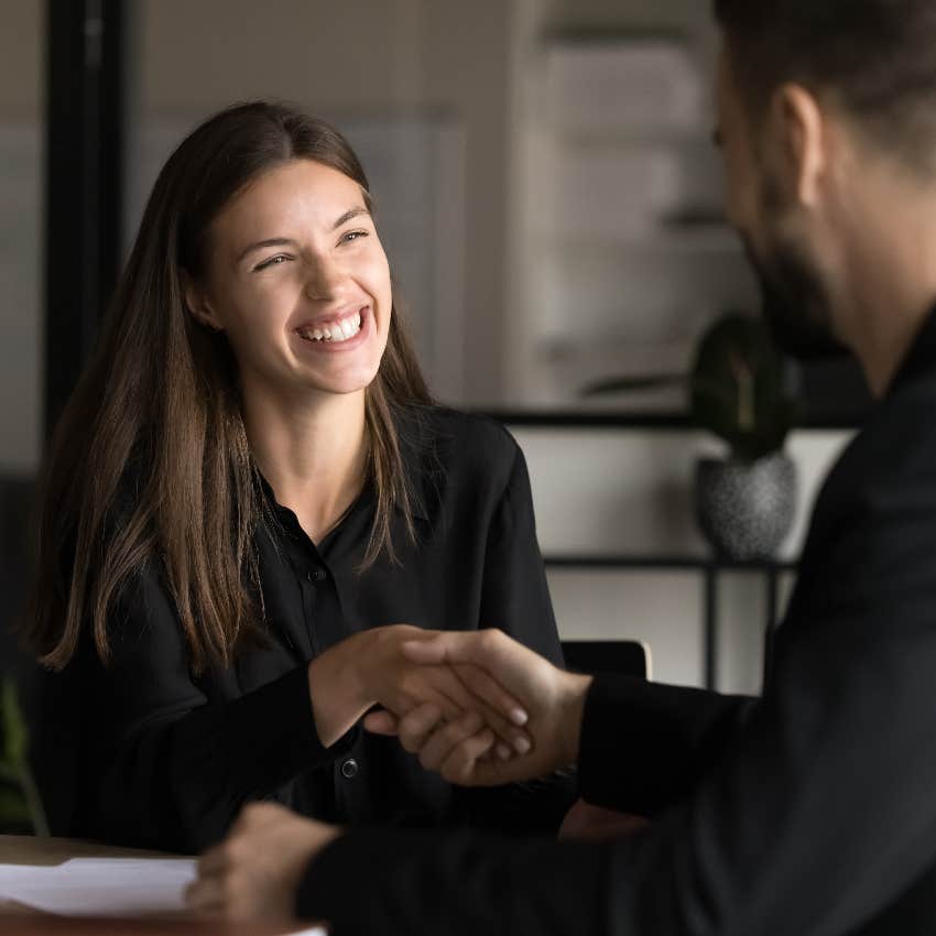 millennial woman shaking hands with employer working her way up the corporate ladder
