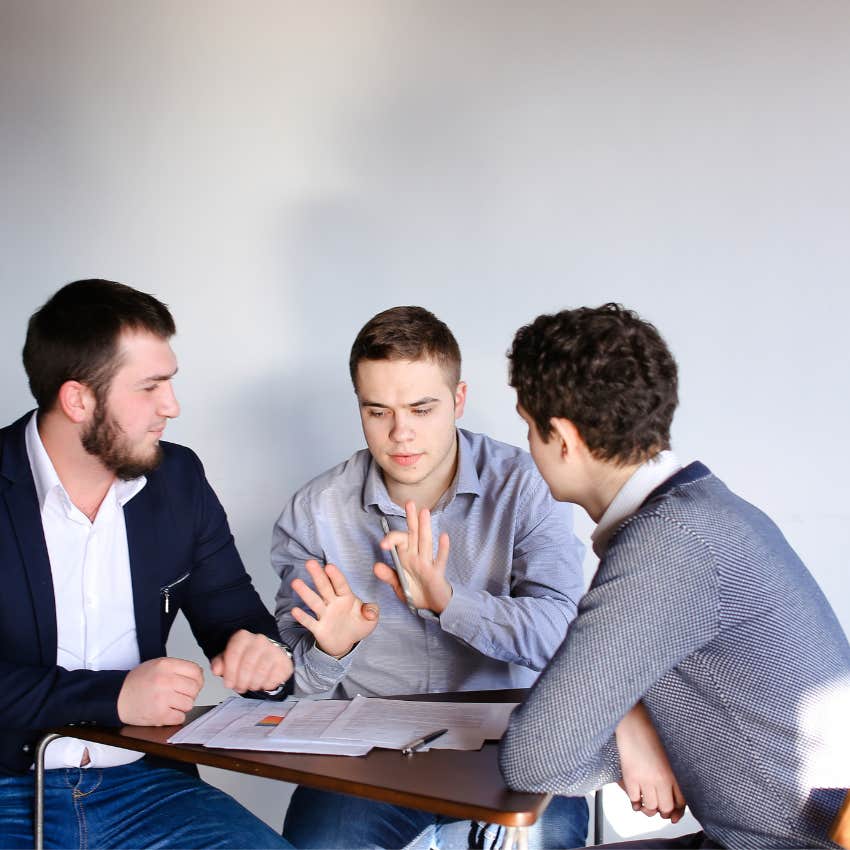 Thoughtful man asking deeper questions during a discussion while others appear ready to move on from the topic
