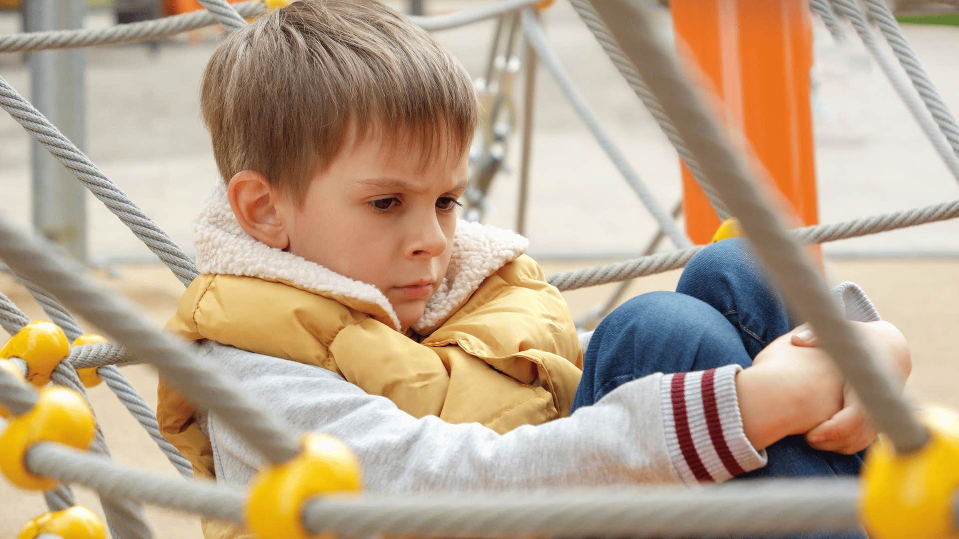 young boy upset on playground about money troubles at home