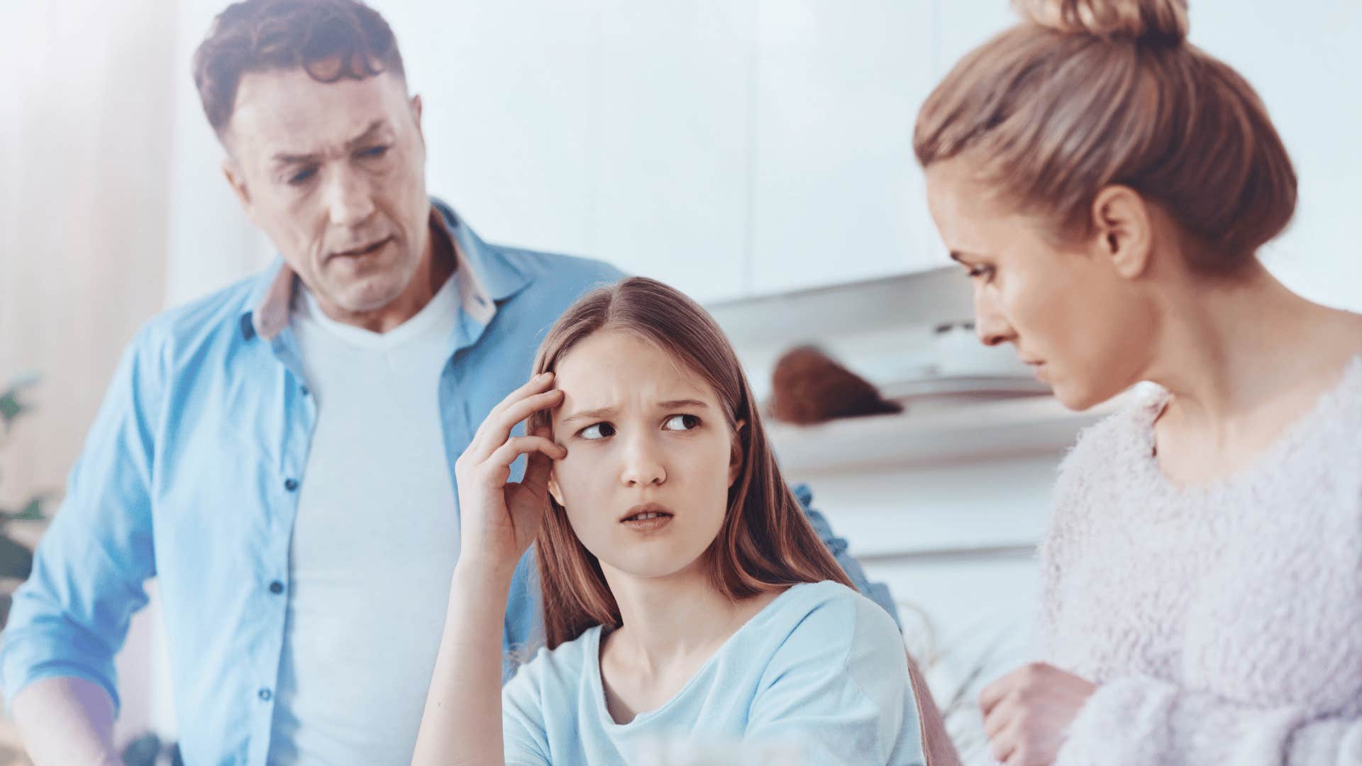 young girl sitting between very critical parents