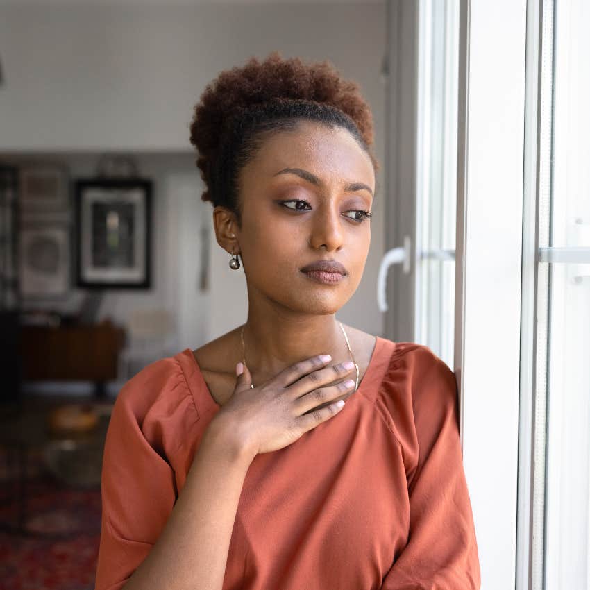 thoughtful woman looking out window dissatisfied with her work life