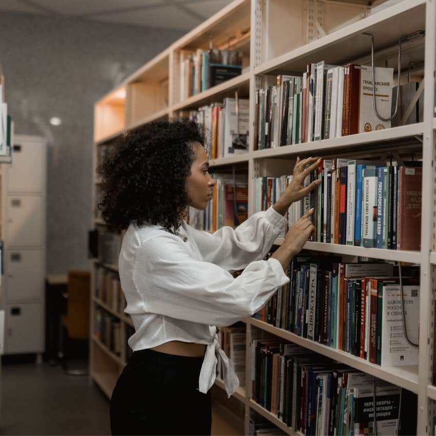 Woman searching through the library to locate a book