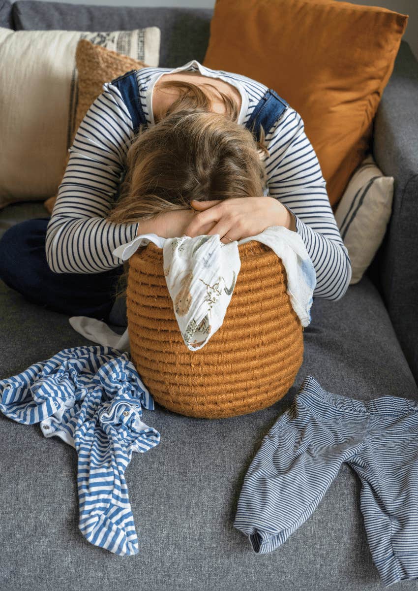 exhausted mom resting her head in a laundry basket
