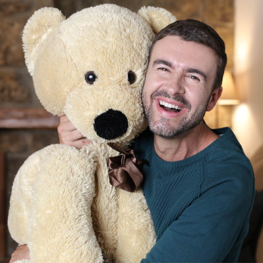 man with a sense of humor hugging teddy bear to cope