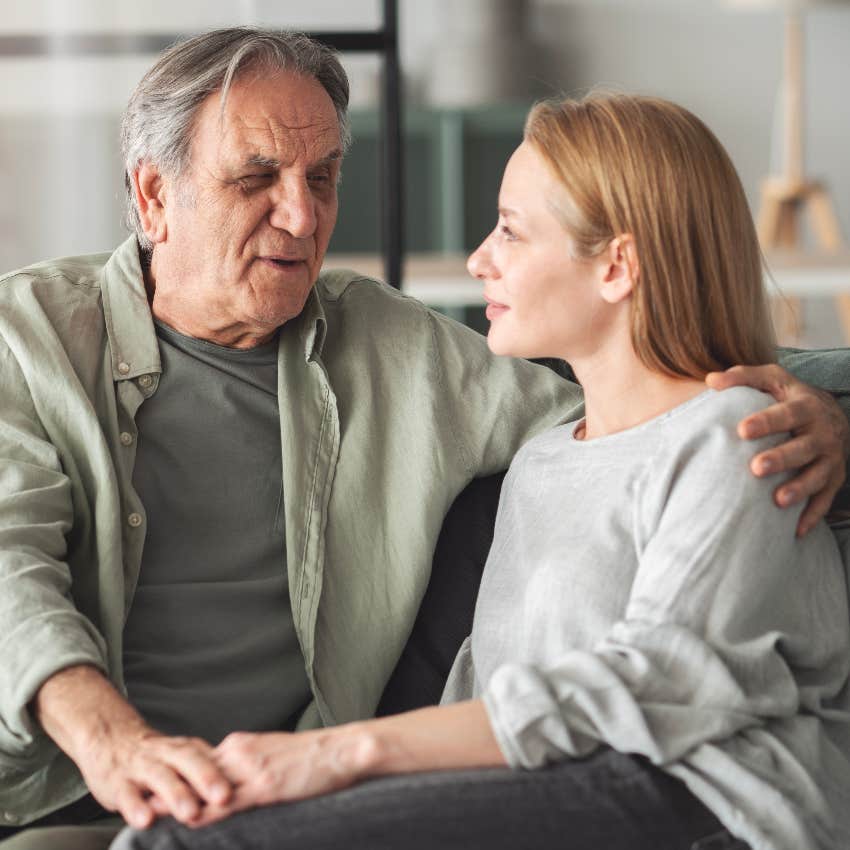 senior father talking to adult daughter on couch
