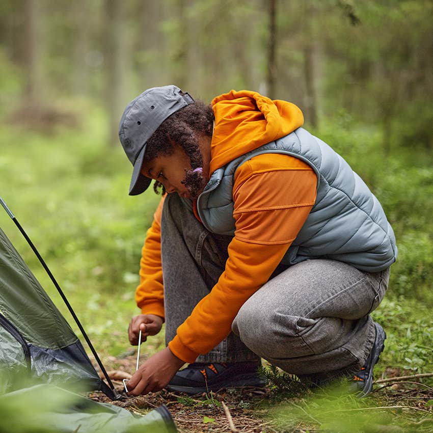teenage girl pitching a tent
