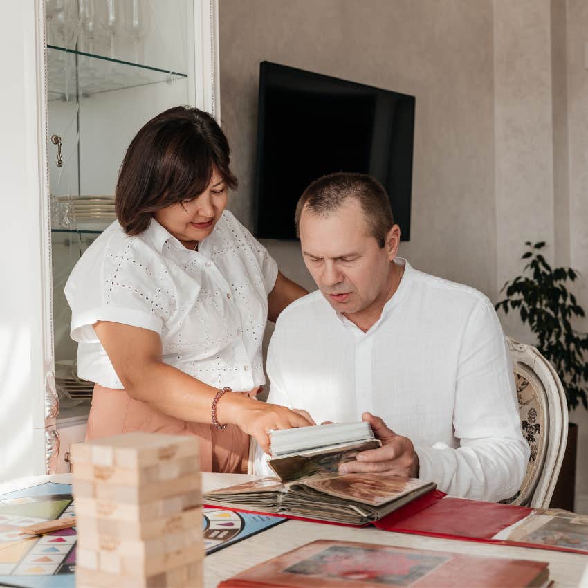 couple looking through a family photo album filled with childhood memories