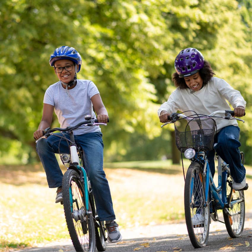 Gen X children riding a bike through a quiet neighborhood