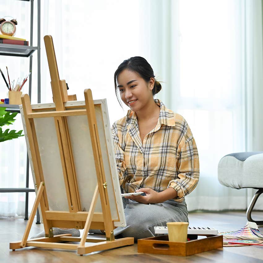 millennial woman enjoying free time by painting