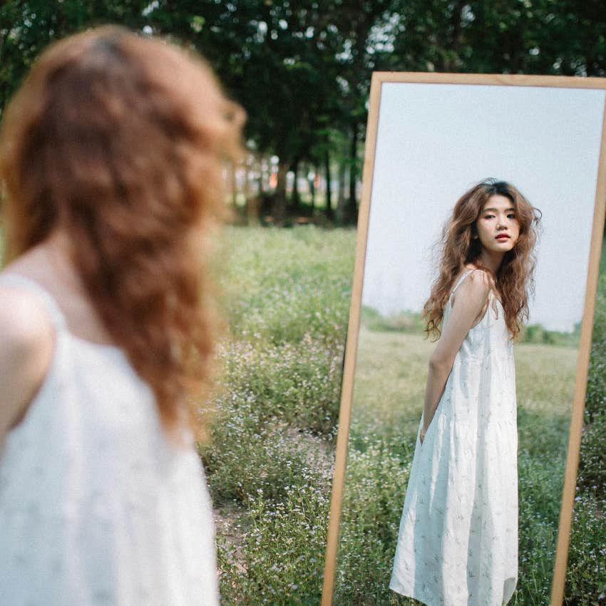 woman feeling insecure as she looks in the mirror