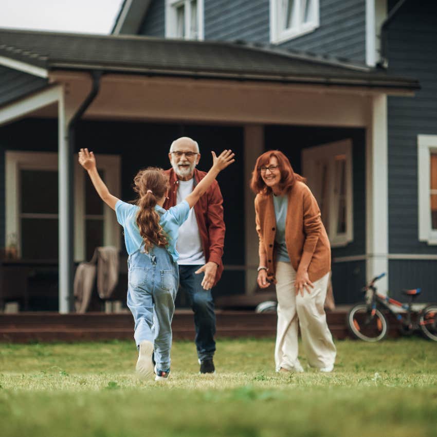 grandparents playing in yard with grandchild