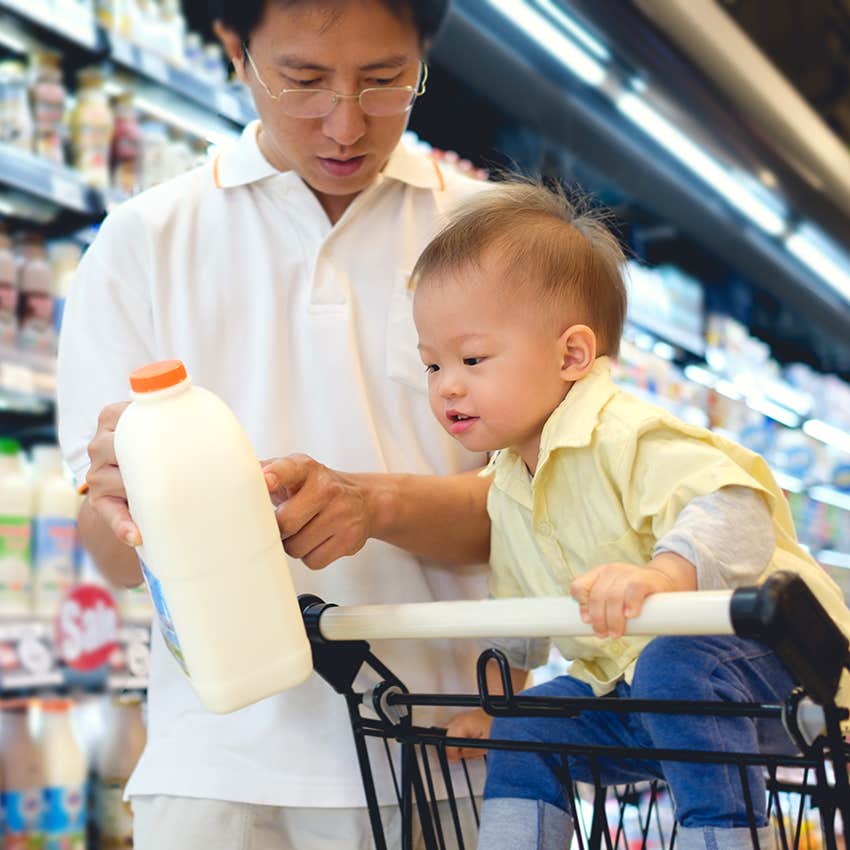 little boy reading milk label with father