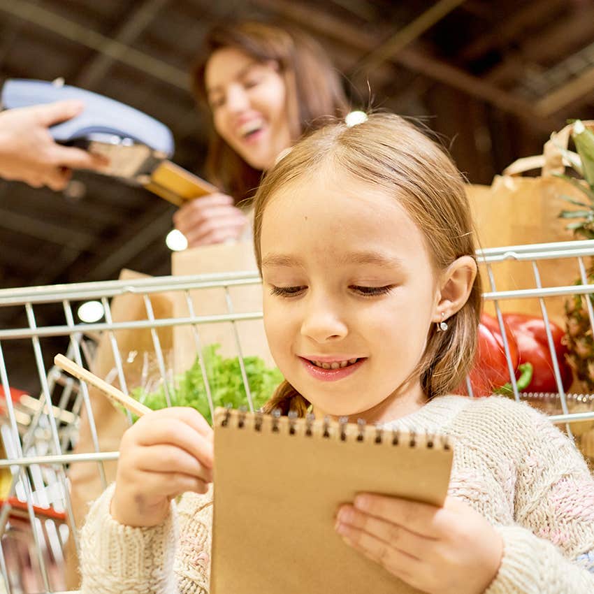 little girl checking off her shopping list 