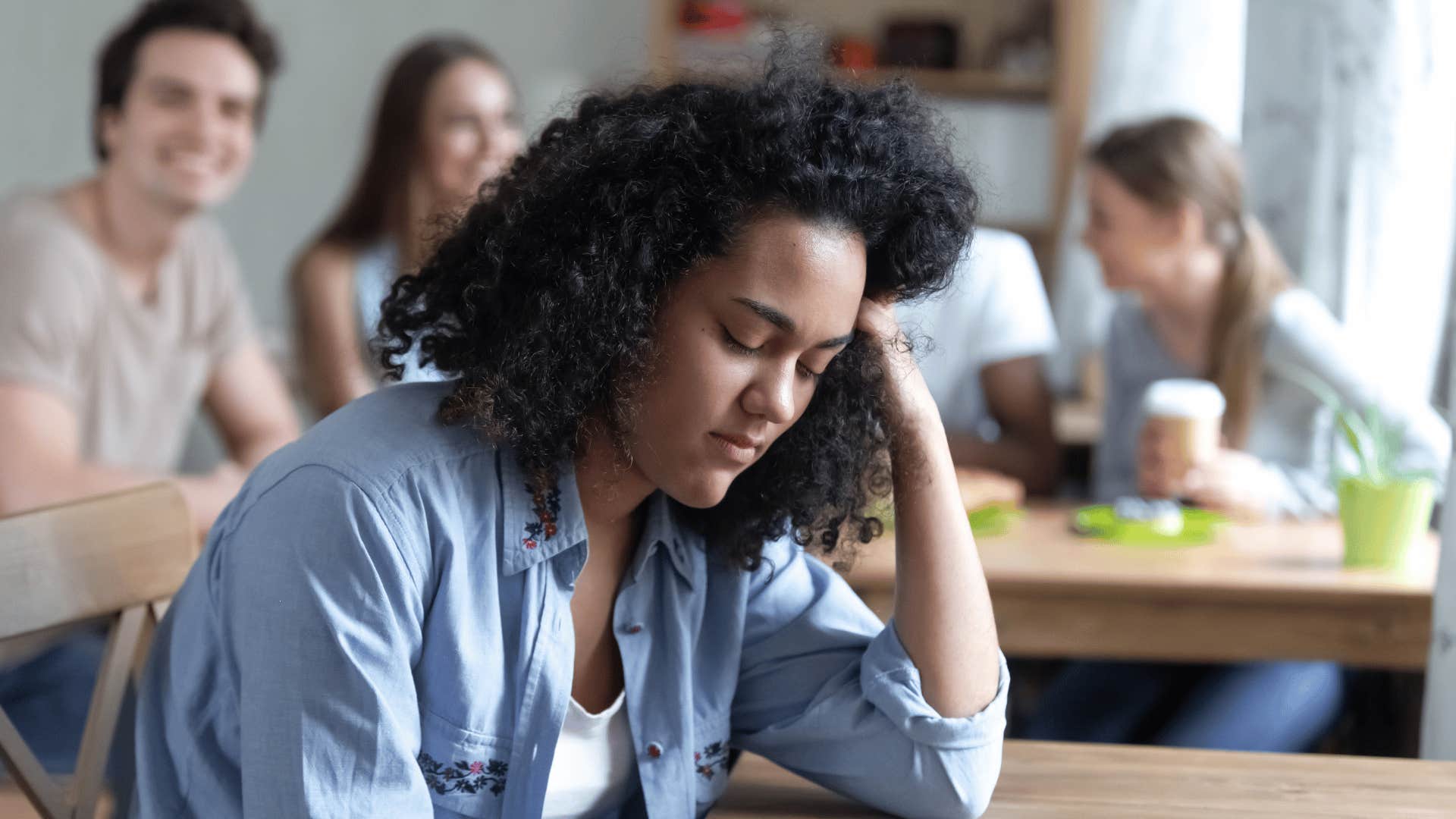 upset woman turned away from friends trying to compliment her